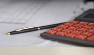 calculator and a pen on a desk with papers