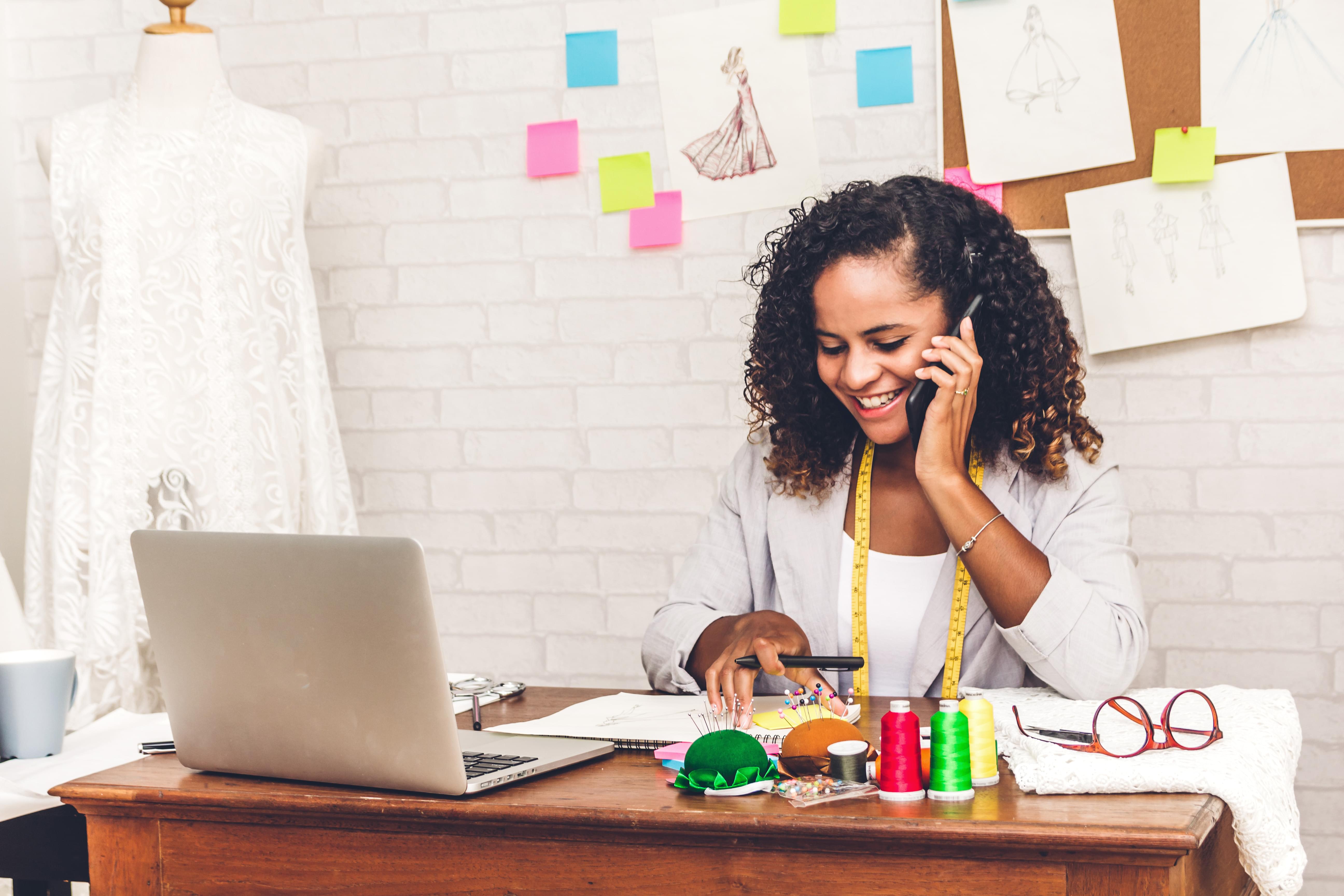 small business owner talks on the phone with customer.