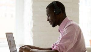 A student wearing headphones taking an online course.