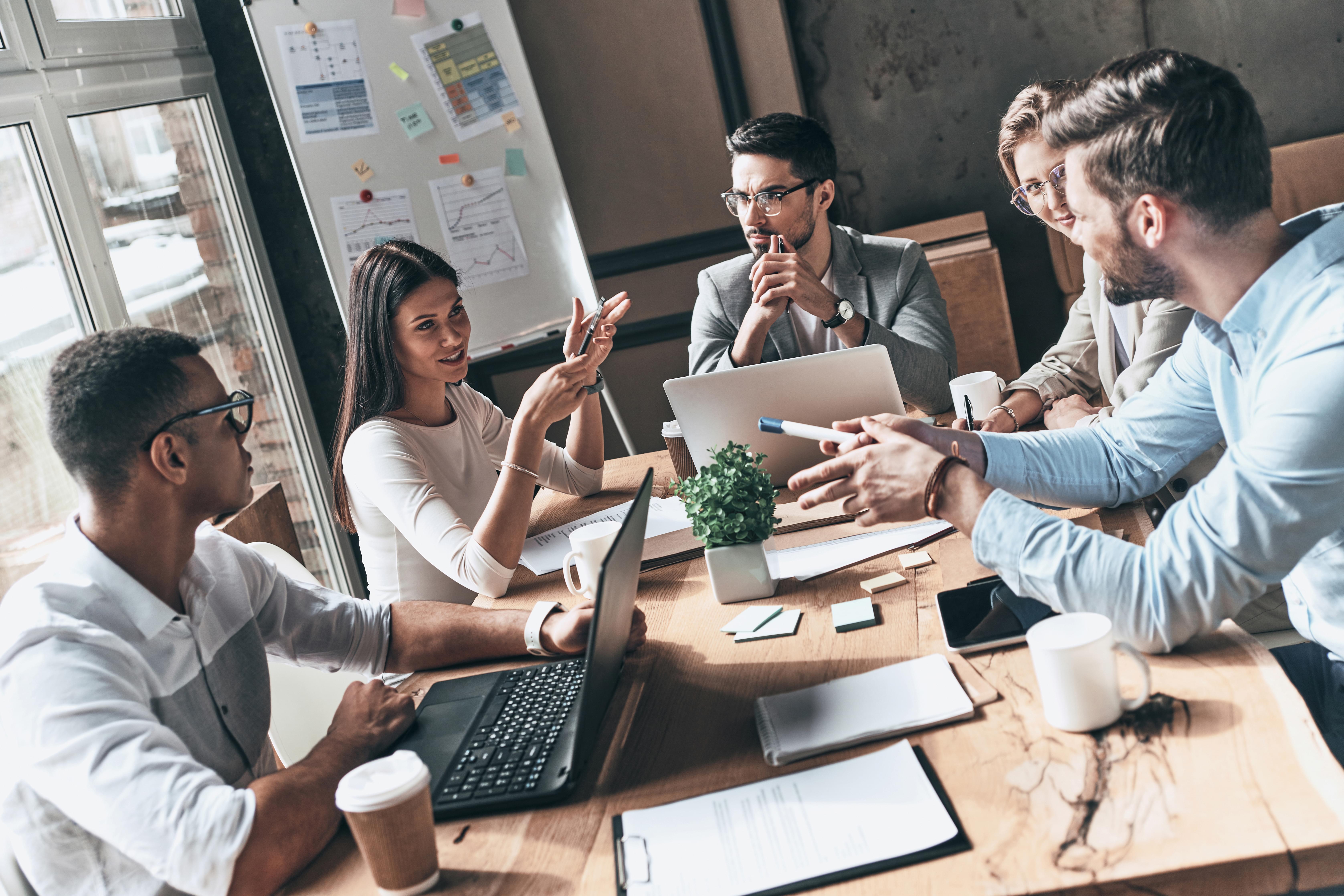  Business professionals having a meeting and using nonverbal communication such as body language, gestures, and facial expressions to communicate with each other.