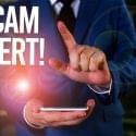 Person holding their cellphone with the caption "Scam Alert" to denote a smishing attack