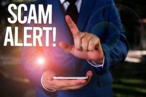 Person holding their cellphone with the caption "Scam Alert" to denote a smishing attack