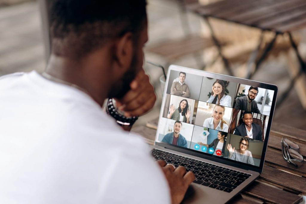 Man getting to know his team through web conferencing software during remote onboarding.