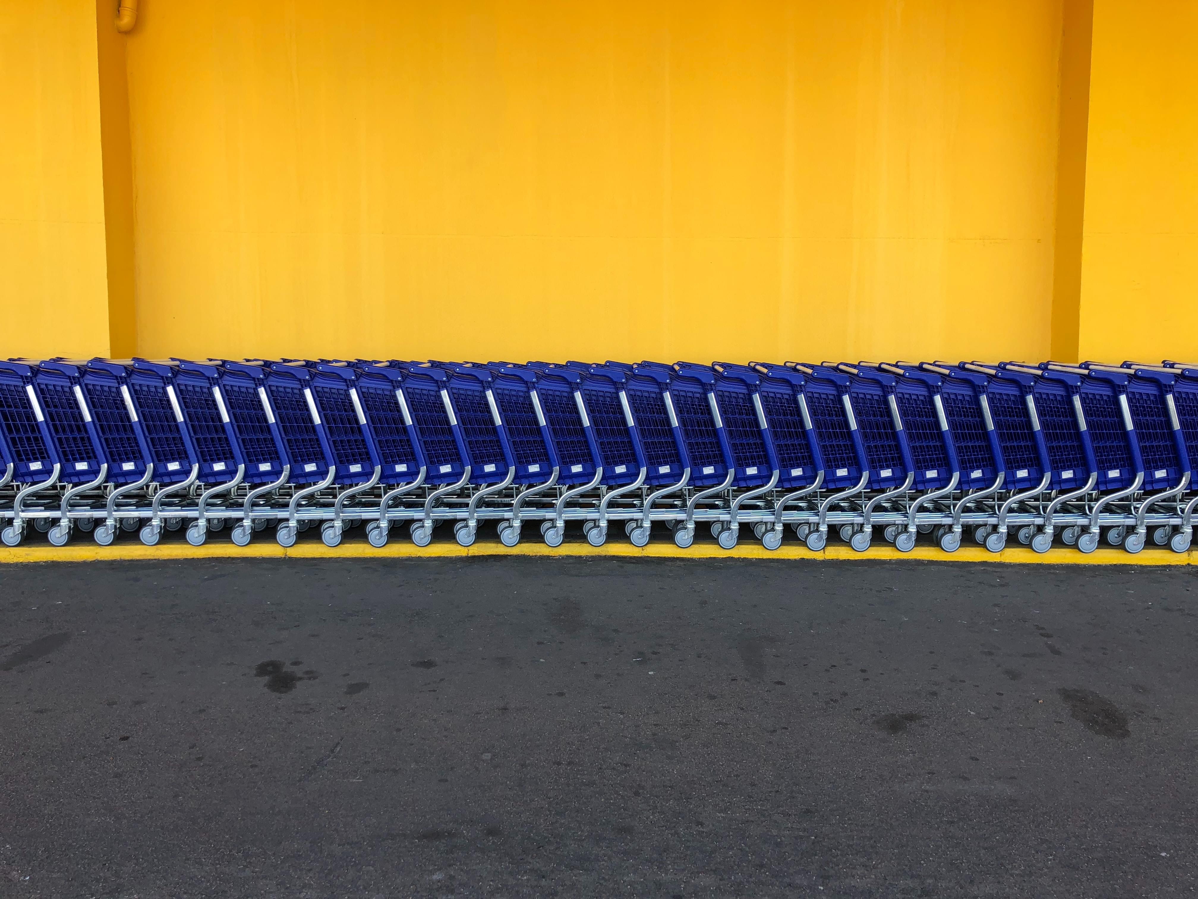 Walmart blue carts against a yellow wall