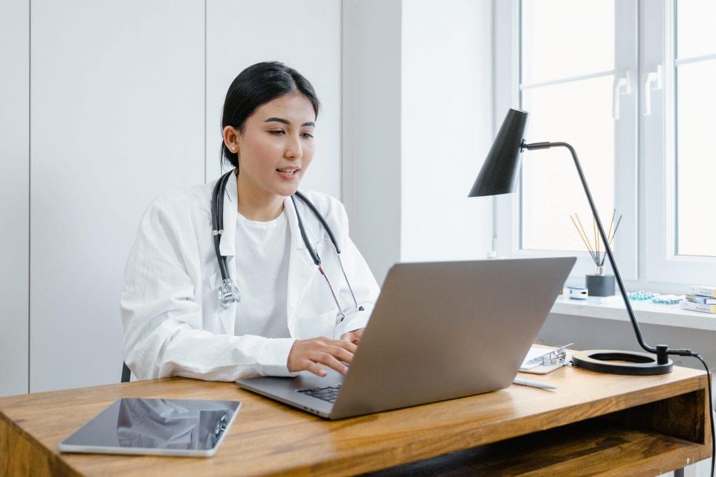 Doctor using healthcare IT services on laptop