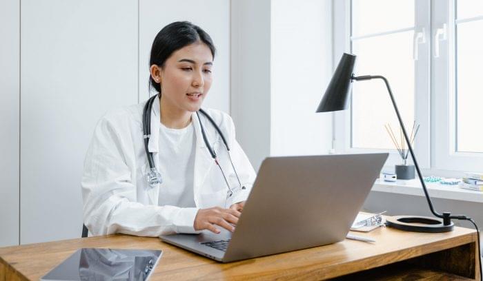 Doctor using healthcare IT services on laptop