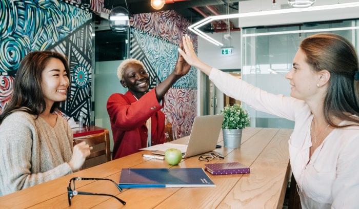 Coworkers high five over conference table