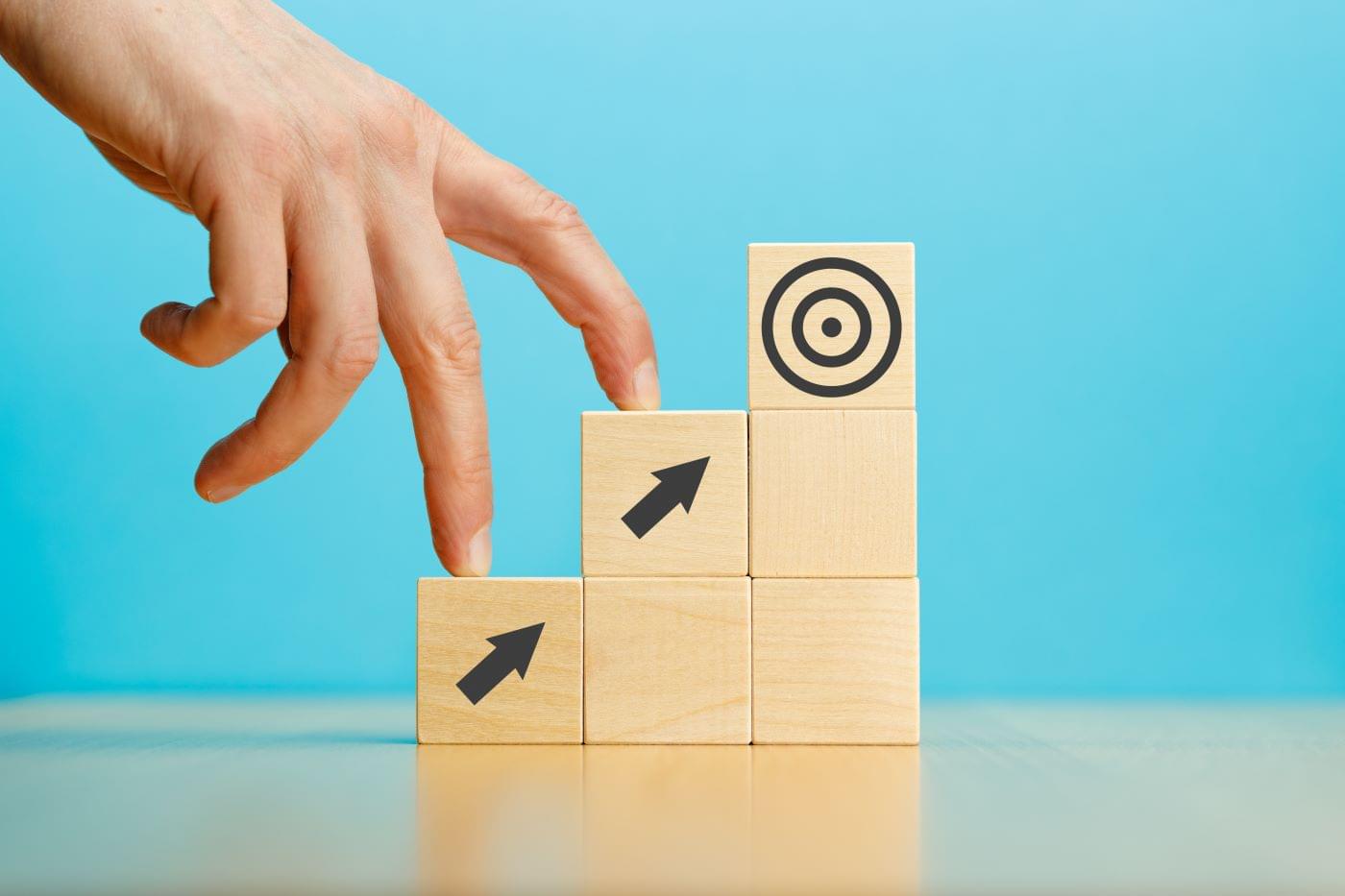 Person walking their fingers up blocks with arrows on them to a block with a target.