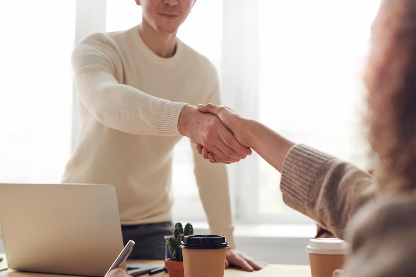 Two people shaking hands at the end of an interview.