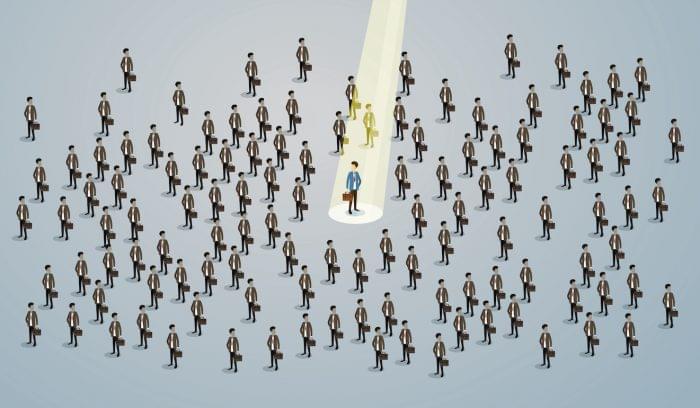 Illustration of a spotlight on one job-seeker in a crowd of many job-seekers. Represents creative ways to find employees.