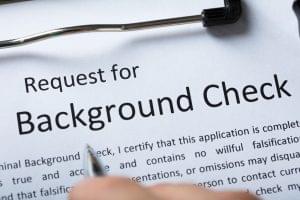 A job candidate fills out a background check consent form. Represents the process of running a background check for employment purposes.