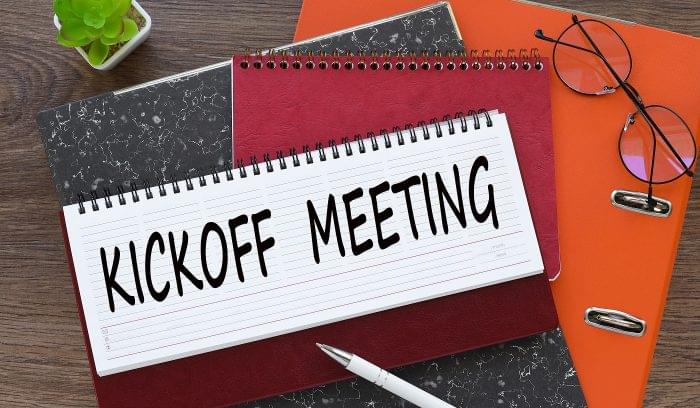 Kickoff Meeting. diary with text on orange folder.