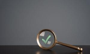 Magnifying glass and green check mark.